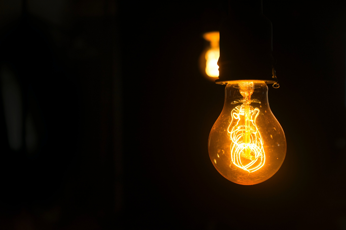 Lightbulb in dark room, representing how some opinions stand out from others. Photo by Daniel Reche (Pexels).